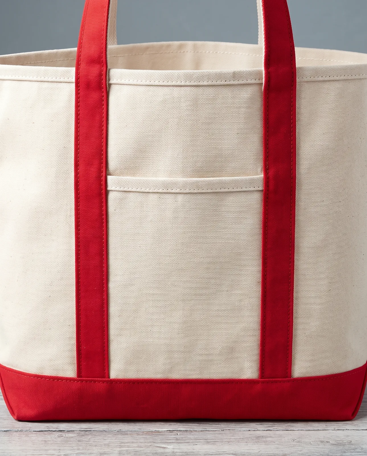 Custom canvas tote bags in Natural / Red, close view of the front pocket, contrast strap stitching and 18 oz canvas