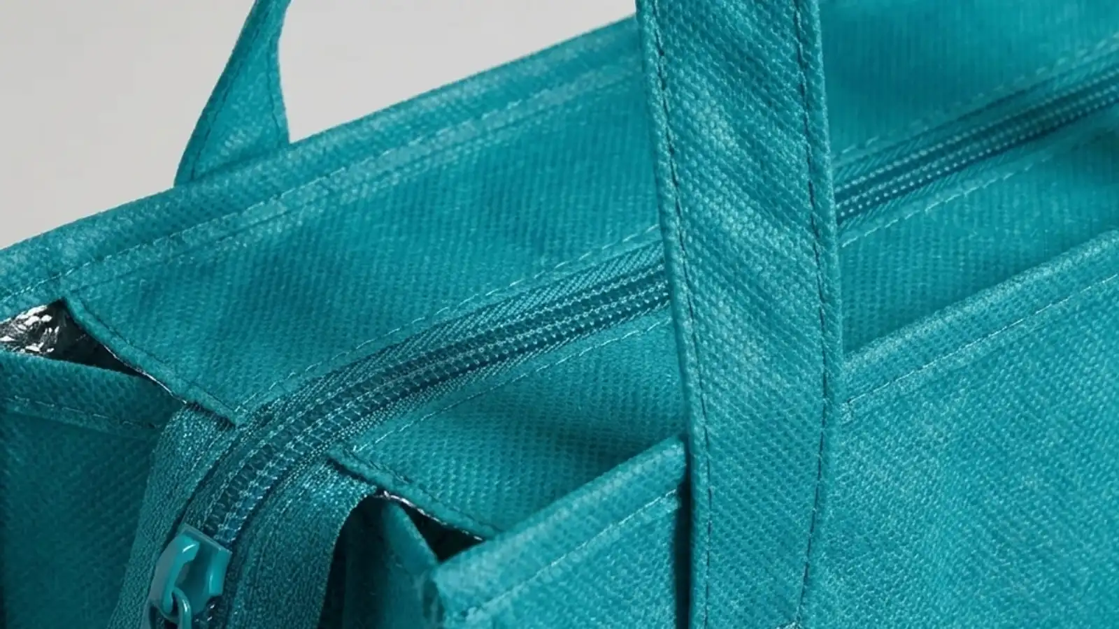 Dual reinforced 24-inch handles and zippered top of custom insulated cooler tote bag