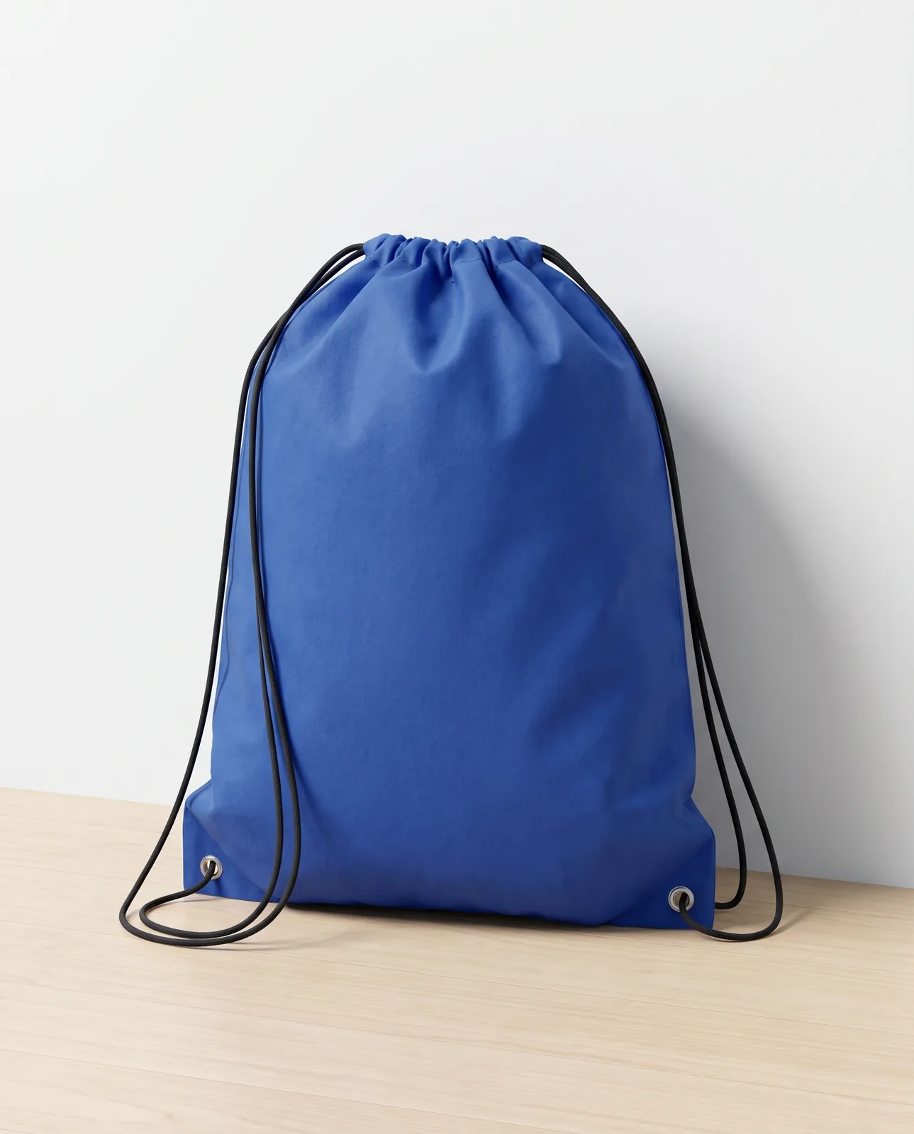 Custom drawstring bags in Royal Blue, 14 x 17 in non-woven backpack with black cinch cord, standing on a maple floor