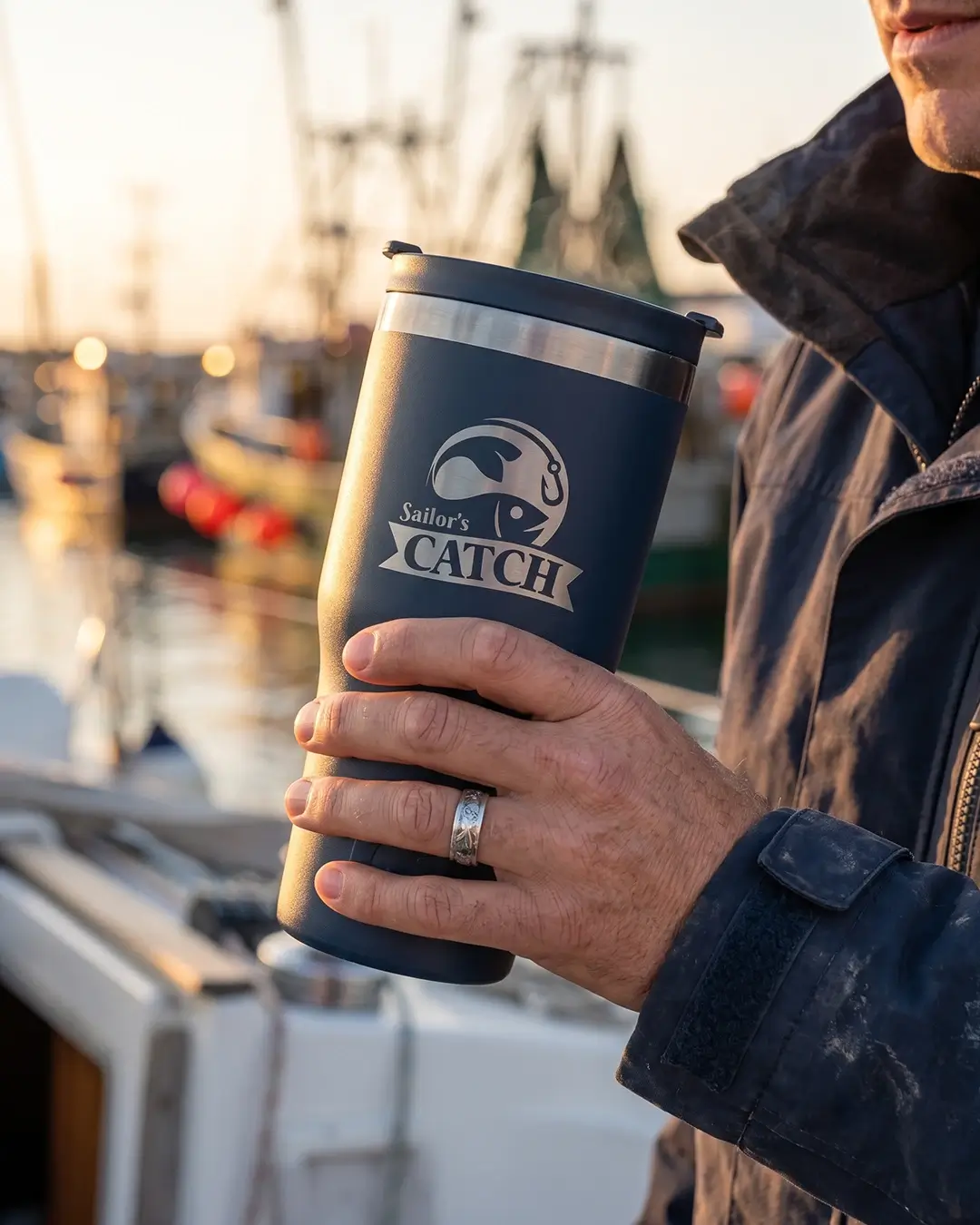 Custom RTIC tumbler in Navy Blue held in hand, showing the engraved logo and matte finish