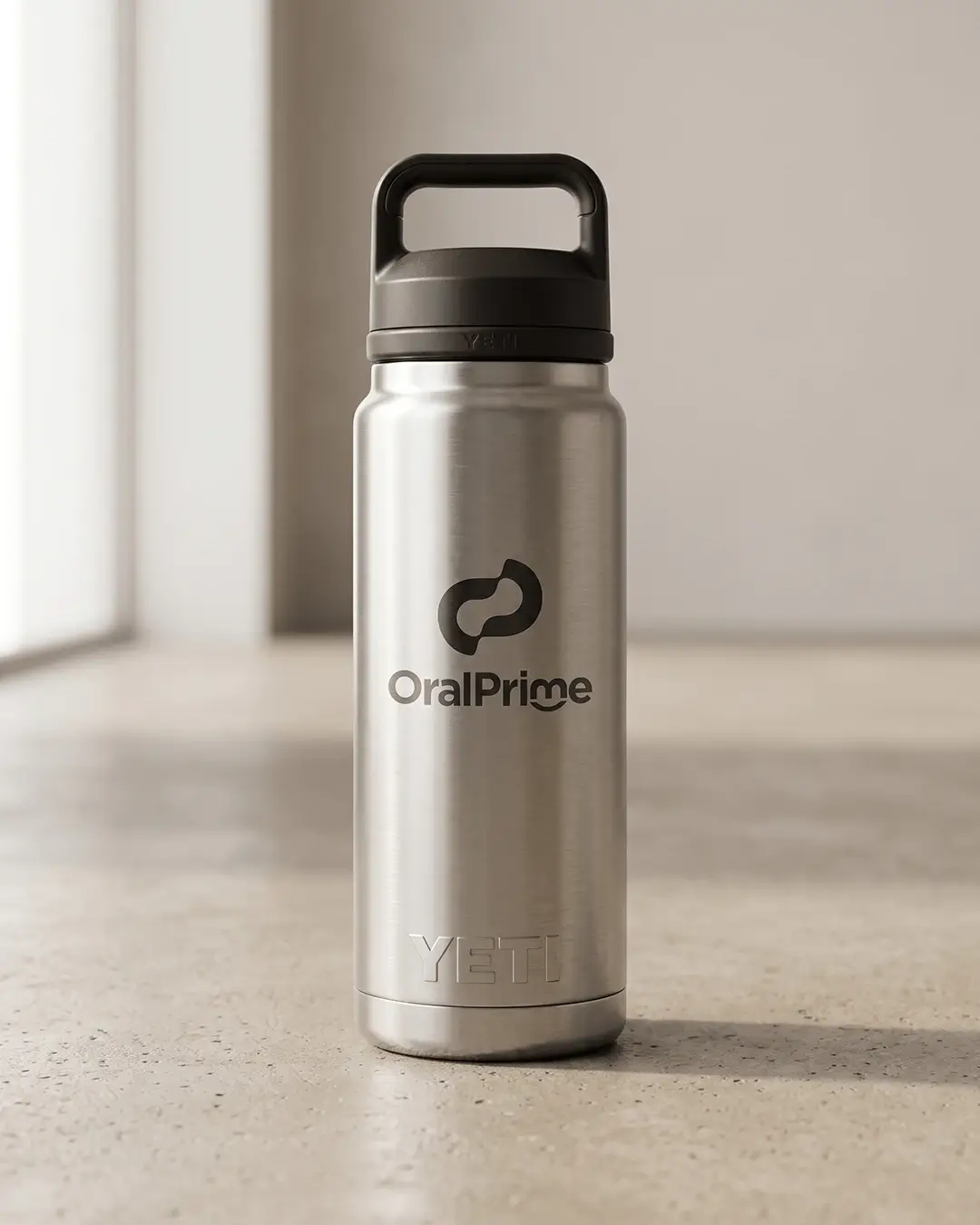 Custom YETI water bottles in stainless, Rambler 26 oz with Chug Cap, laser engraved logo mockup on a concrete floor