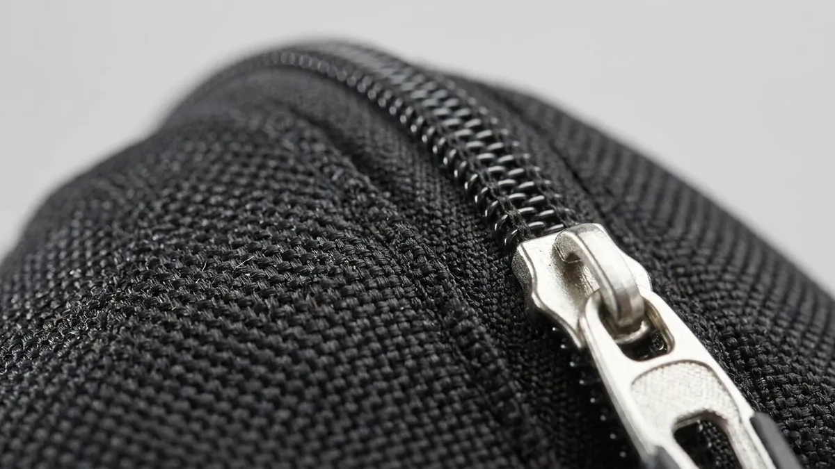 Black ballistic-weave polyester and silver zipper detail of a custom laptop backpack — Brandevois