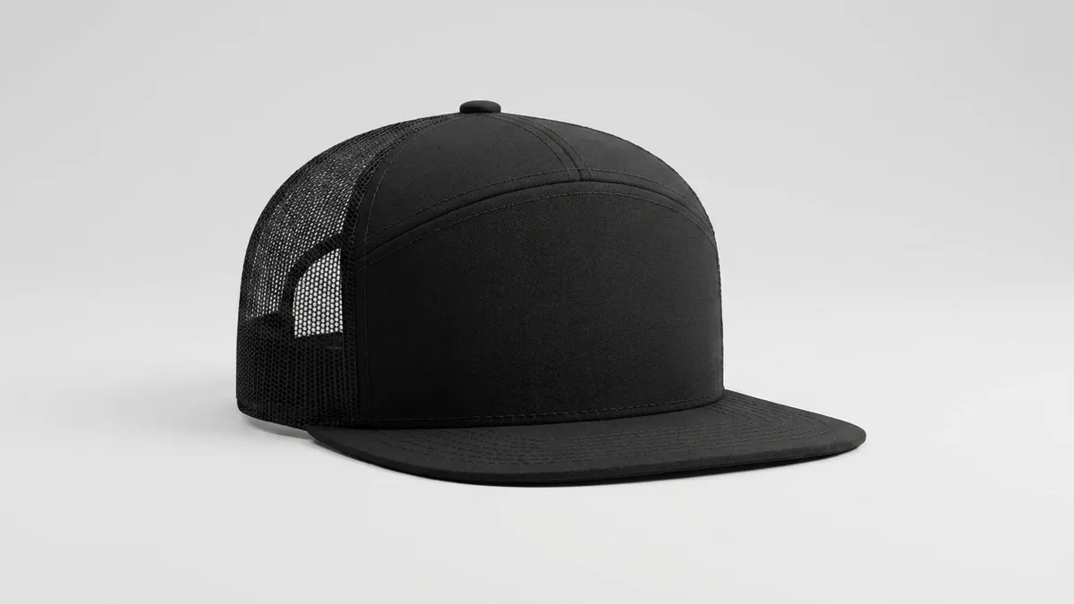 Close-up of a custom 7-panel snapback trucker cap showing the structured cotton front, flat bill, and mesh back with embroidery space by Brandevois