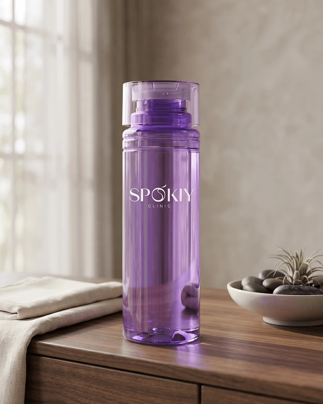 Promotional water bottles on a wood counter beside towels with the logo facing out