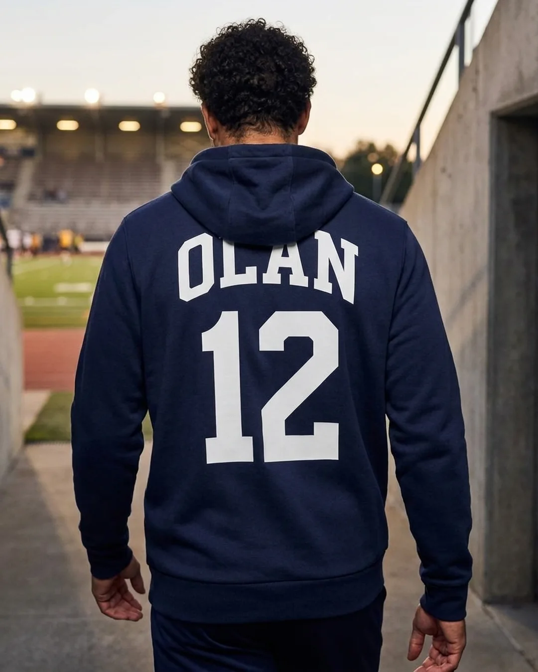 Custom team hoodies with a team name and player number printed across the back of a navy Under Armour hoodie