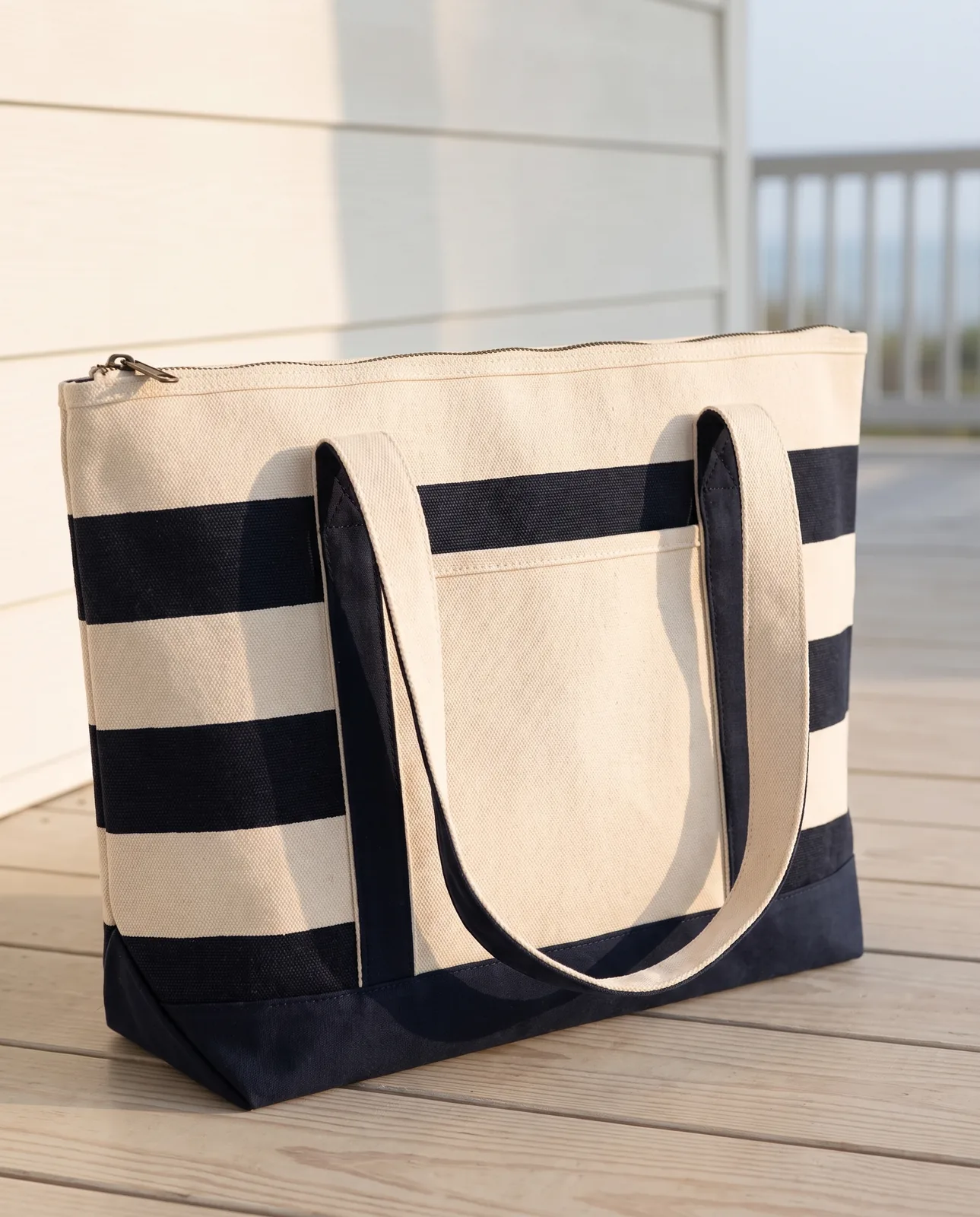 Custom boat totes with zipper in Natural / Navy Blue, close view of the closed zip top with metal pull, stripes and front pocket
