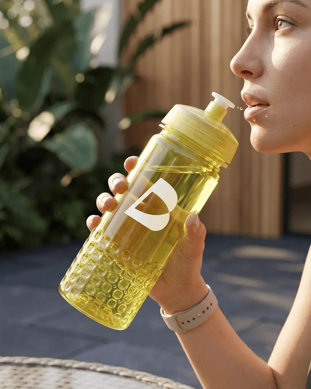 Woman drinking from a custom translucent yellow sports water bottle with a white printed logo