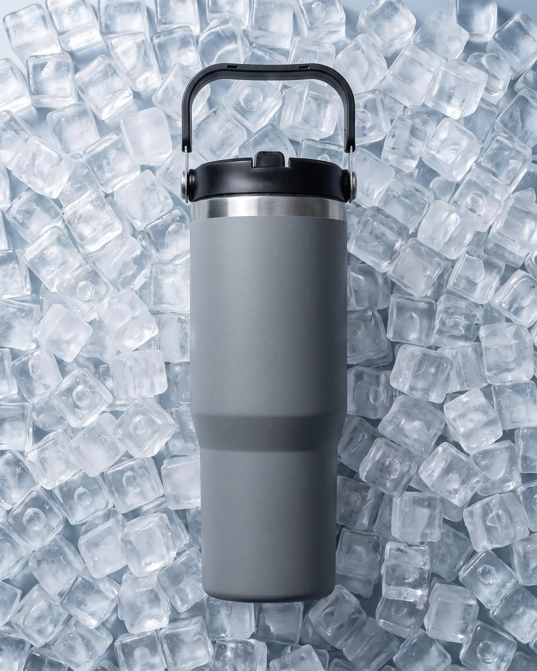 Gray 30 oz vacuum insulated custom tumbler resting on a bed of ice cubes with a dry, sweat-free outside