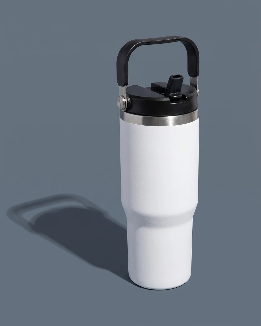 White 30 oz custom tumbler on a slate backdrop with its swivel carry handle raised over the lid and the flip-up straw spout open